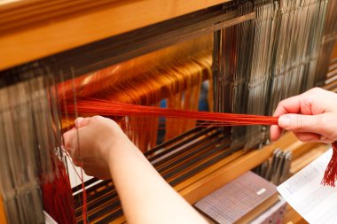 Hands of a woman who weaves on a loom clipart