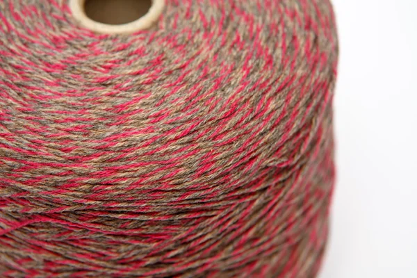 Beyaz bir arka plan üzerinde renkli yün iplik konisi