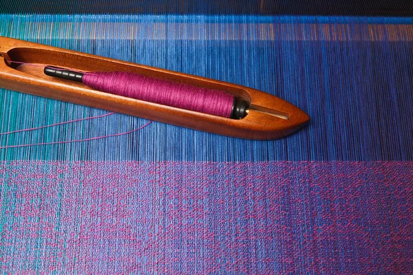 Ткацький човник з ниткою на блакитній шпажці — стокове фото