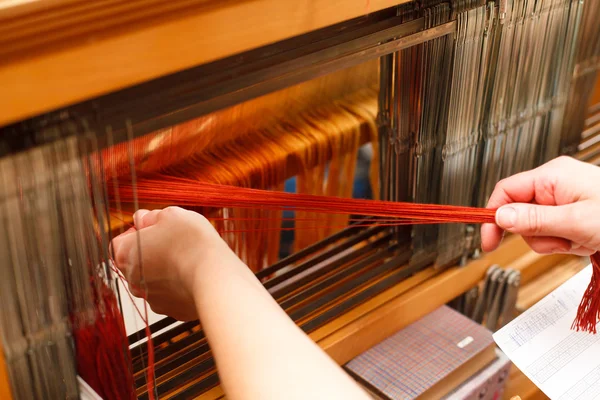 Hands of a woman who weaves on a loom — Stock Photo, Image