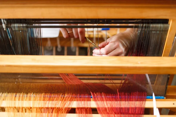Руки жінки, яка плететься на ткацькому верстаті — стокове фото