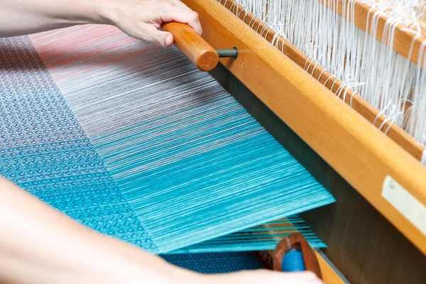 Руки жінки, яка плететься на ткацькому верстаті — стокове фото
