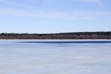 Donmuş göl ve bulutlu gökyüzü.