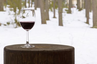 Cam kadehi ağaçlar bir arka plan üzerinde kırmızı şarap. 