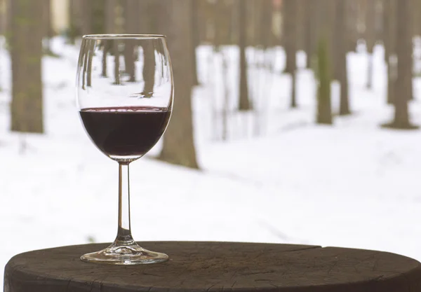 Красное вино в стакане бокала на фоне деревьев . — стоковое фото