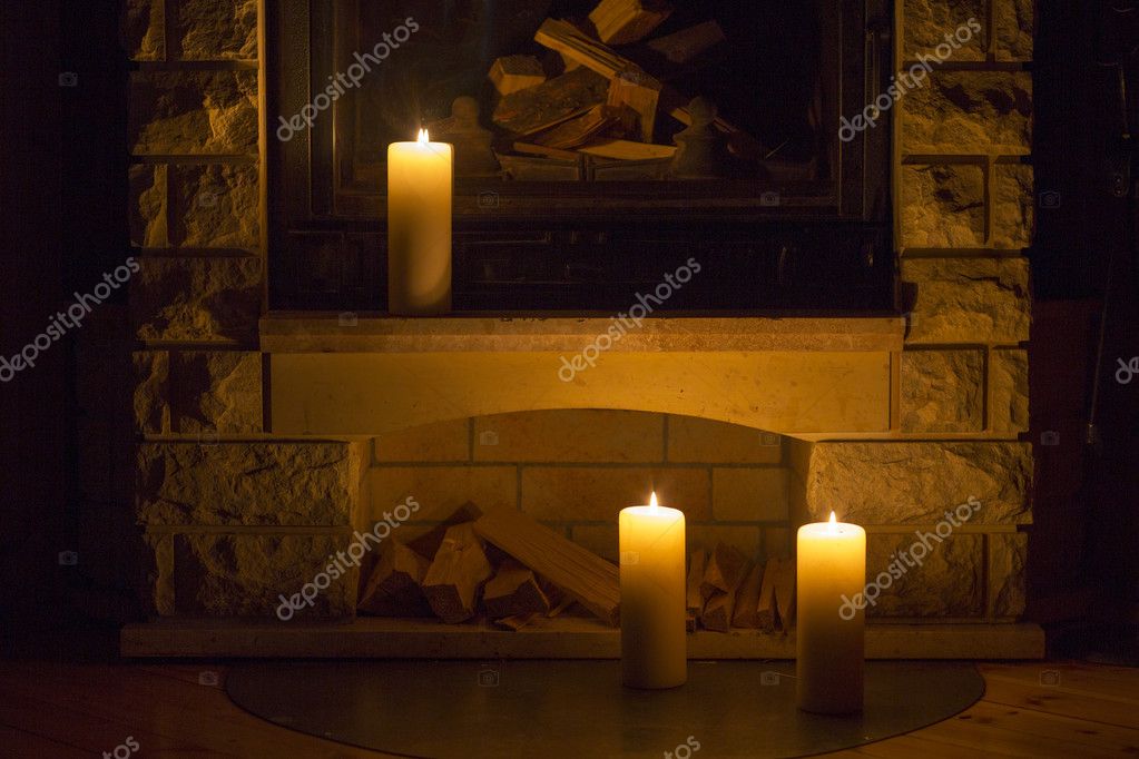 White Large Candles Standing On The Fireplace Stock Photo