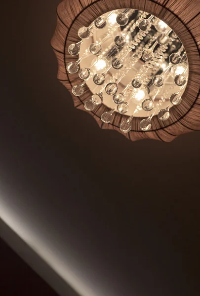 Un lampadario illuminato, interno camera da letto . — Foto Stock