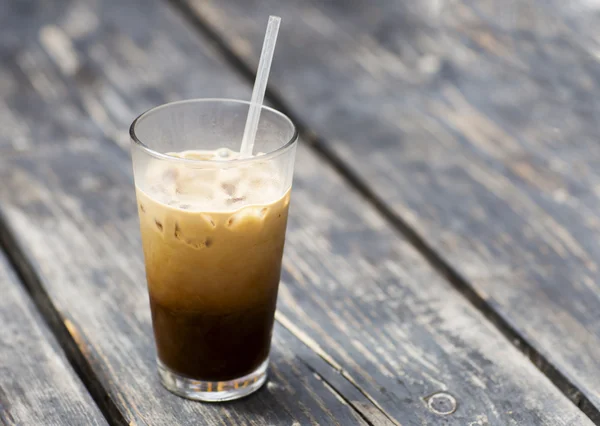 Cold coffee with milk in a glass beaker.