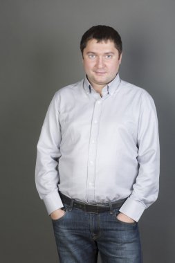 Adam bir gömlek ve gri arka plan üzerinde kot pantolon. 