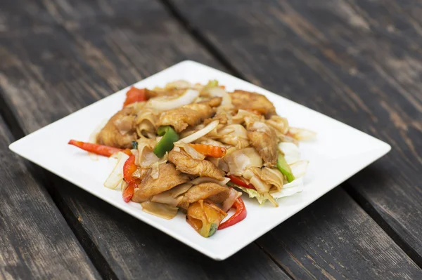 Comida tailandesa para el almuerzo en un plato sobre una mesa de madera . — Foto de Stock