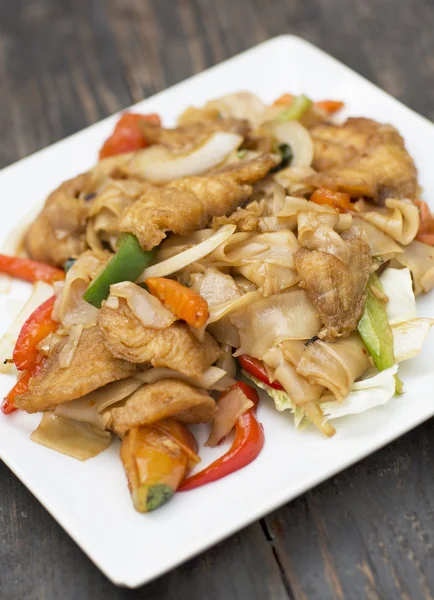 Comida tailandesa para el almuerzo en un plato sobre una mesa de madera . — Foto de Stock