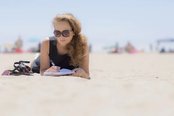 Girl on the beach with a notebook. — Stock Photo, Image