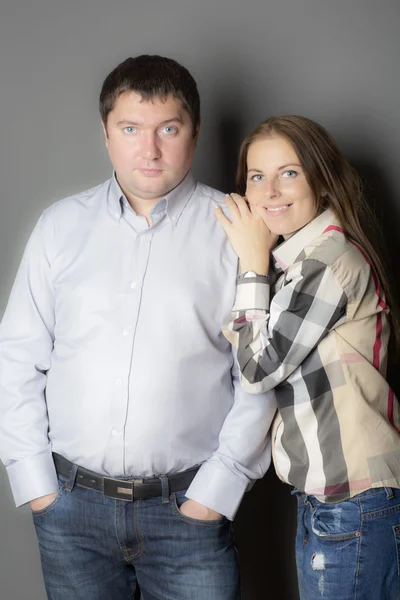 Retrato de una joven pareja sobre fondo gris . — Foto de Stock