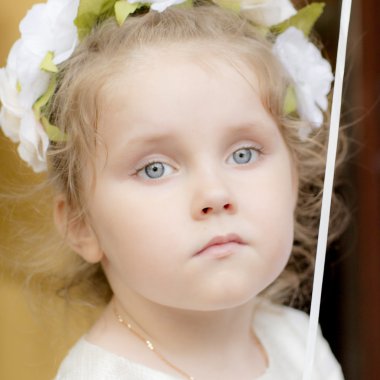 Kafasında bir çelenk ile beyaz elbiseli kız.