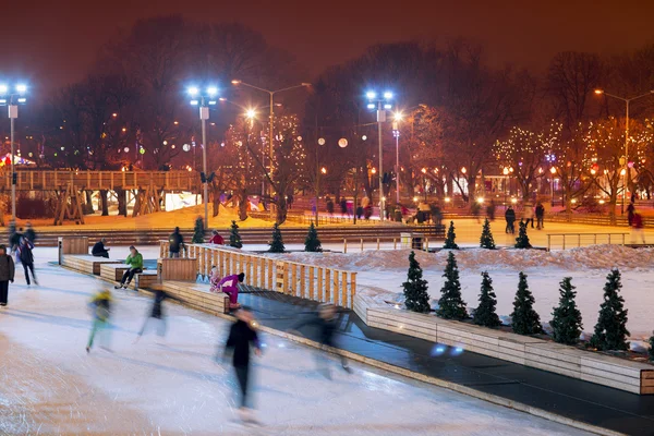 Οι άνθρωποι κάνουν πατινάζ το βράδυ στο πάρκο το χειμώνα. Royalty Free Εικόνες Αρχείου