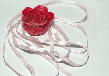 Beyaz bir arka plan üzerinde kurdele ile gül.
