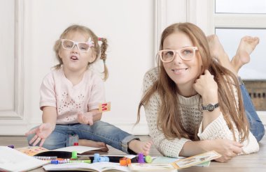 Kadın bir çocuk çizmek için yardımcı olur..