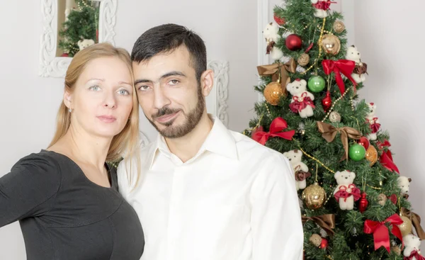 Retrato de un hombre y una mujer cerca del árbol de Navidad . — Foto de Stock