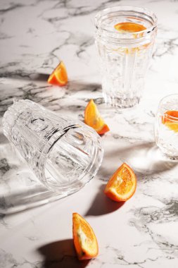 Mutfak masasında yemek artıkları var. Kristal bardaklar ve mandalina dilimleri   