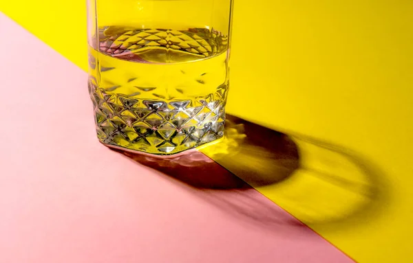 Pembe ve sarı renkli arka planda bir kristal cam.