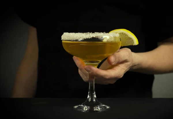 Siyah elbiseli bir kadın elinde kokteyl olan bir bardak tutuyor. Kadın alkolizmi