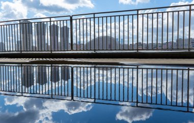 Şehir manzarası Moskova, su birikintisindeki metal yapılar, korkuluklar, güneşli bir bahar günü güzel bulutlar.