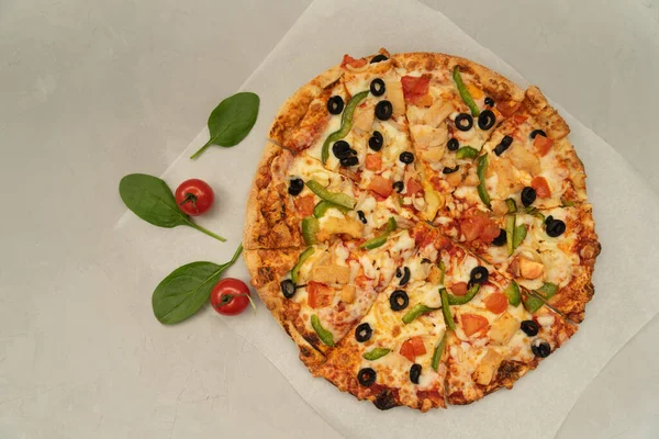 Gri arka planda yeşil biberli, tavuk, peynir ve domatesli leziz iştah açıcı pizza. Dünyanın her yerinde popüler yiyecekler..