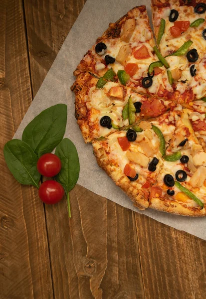 Tahta bir masada lezzetli bir pizza, üst manzara, dikey fotoğraf.