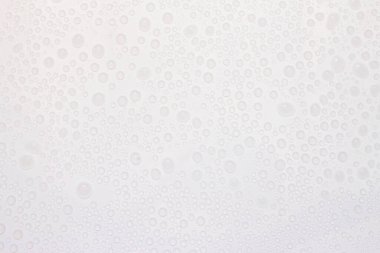 Beyaz yüzeyde arkaplan olarak su damlası