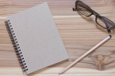 Kahverengi ahşap zeminde bir kalem kitabı..