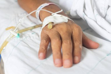 Beyaz battaniyeli hastaya damar yoluyla bulaşan eller.