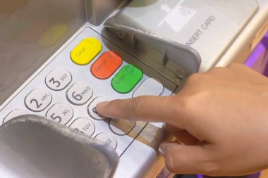 Asyalı bir kadının eli ya da ATM makinesindeki tuşlara basıyor.