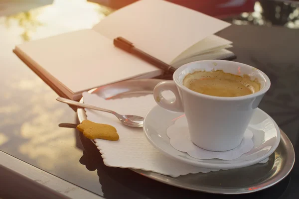 Bloc de notas, bolígrafo, taza de café. Cafés callejeros en el casco antiguo . Imagen De Stock