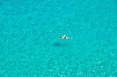 Genç kadın yalnız yüzüyor.