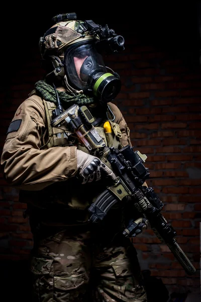 Soldier with rifle and respirator on dark background — Stock Photo, Image