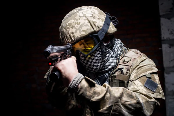 Muž ve vojenské uniformě s pistolí v ruce — Stock fotografie
