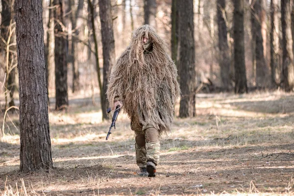 Soldado en traje de francotirador camuflado caminando con arma — Foto de Stock