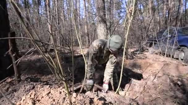 Soldier digs pit in forest — Stock Video