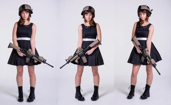 Chica joven en vestido negro y casco con pistola — Foto de Stock