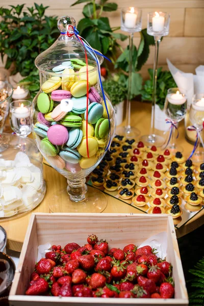 Dessert d'été aux baies et macarons sur une table en retsorane — Photo