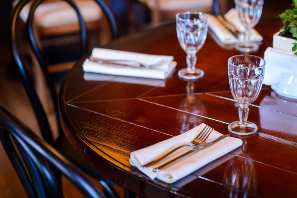 Empty glasses set on wooden table at restaurant — Stock Photo, Image