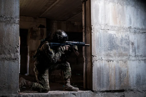 Soldado apuntando un rifle en ruinas — Foto de Stock