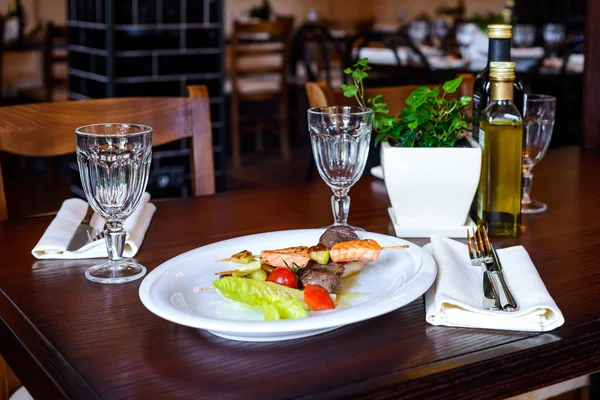 Skewers of salmon and tuna with cherry tomatoes and salad leaf — Stock Photo, Image