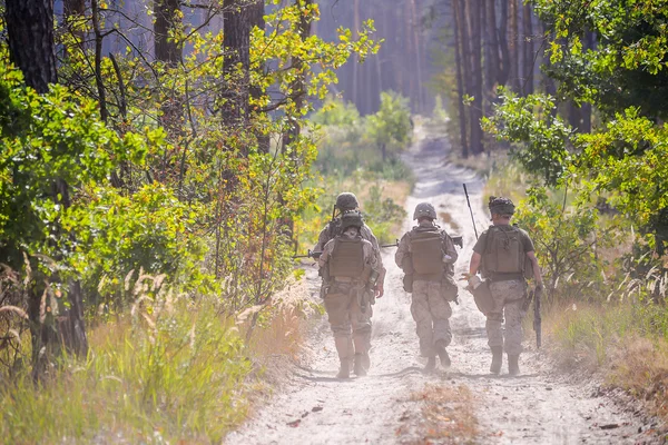 Grupo de soldados armados en la carretera en el bosque — Foto de Stock