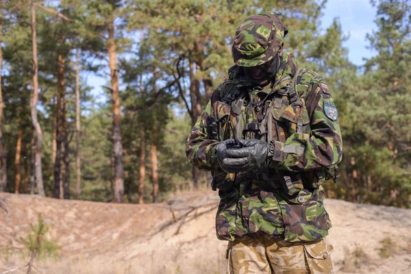 Hombre en uniforme militar con radio portátil en el bosque — Foto de Stock