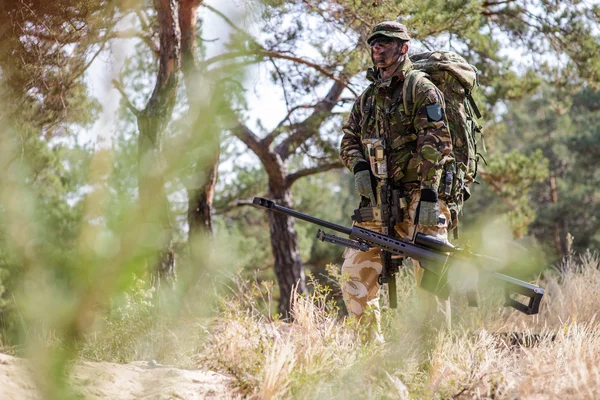 Väpnade soldat med prickskyttegevär i skogen — Stockfoto