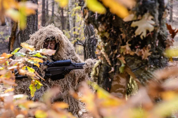 Camouflaged sniper lying in forest and aiming through his scope Stock Photo  by ©Nesterenko_Max 89112398