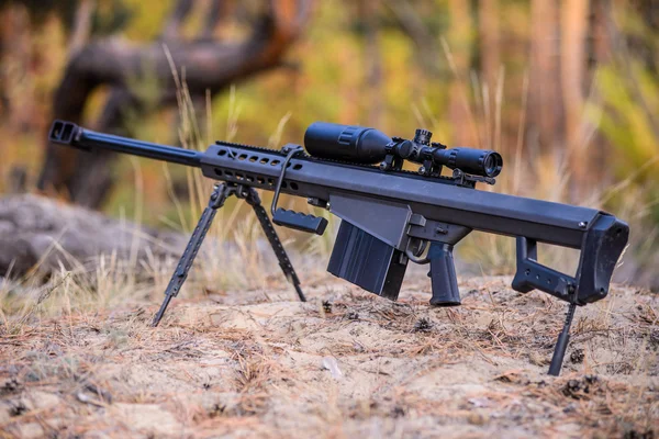 Rifle de francotirador en bípode sobre fondo forestal — Foto de Stock