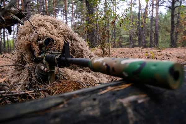 Voják v maskovací oblek s odstřelovací puškou v lese — Stock fotografie