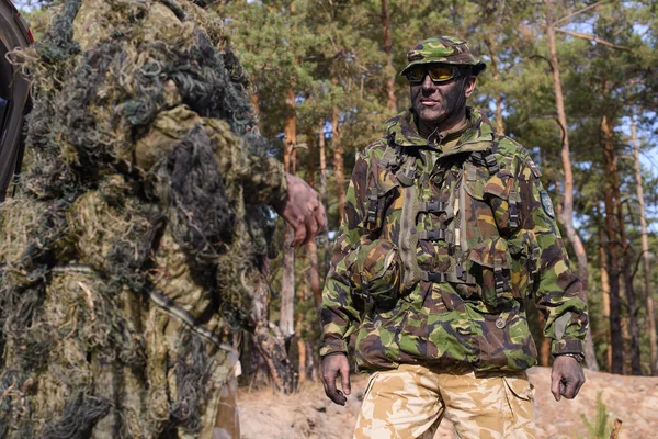 Camouflaged sniper lying in forest and aiming through his scope Stock Photo  by ©Nesterenko_Max 89112398